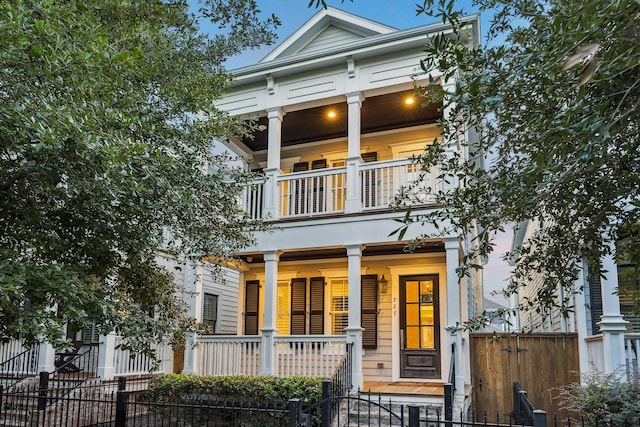 727 Tulane St, Houston, TX 77007 - greek revival house featuring a balcony, covered porch, and a fenced front yard