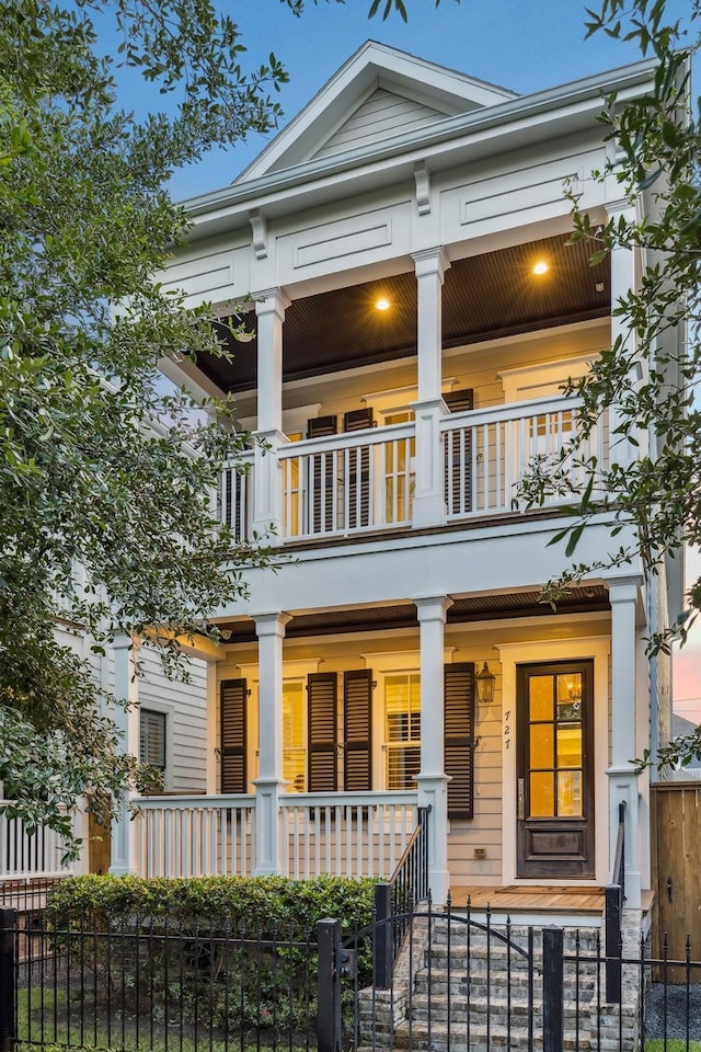 727 Tulane St, Houston, TX 77007 - neoclassical / greek revival house featuring a balcony, a porch, and a fenced front yard