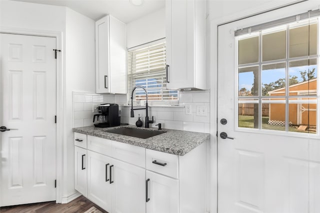 605 Waco St, Dayton, TX 77535 - kitchen featuring tasteful backsplash, white cabinetry, and light stone counters