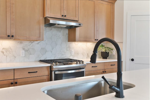24526 Bluestar Blossom Trl, Katy, TX 77493 - kitchen with gas stove, under cabinet range hood, light countertops, and decorative backsplash