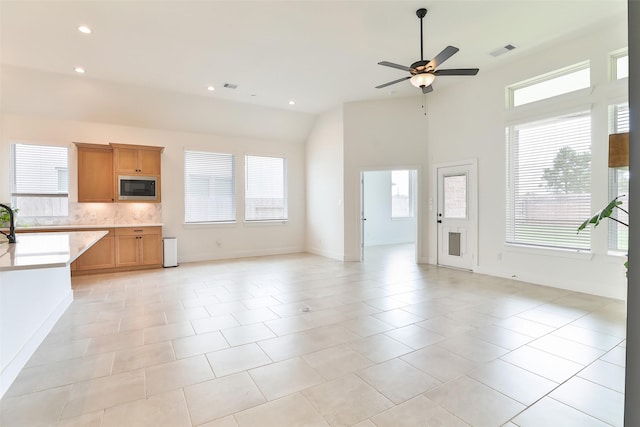 24526 Bluestar Blossom Trl, Katy, TX 77493 - unfurnished living room featuring ceiling fan, recessed lighting, light tile patterned floors, and high vaulted ceiling