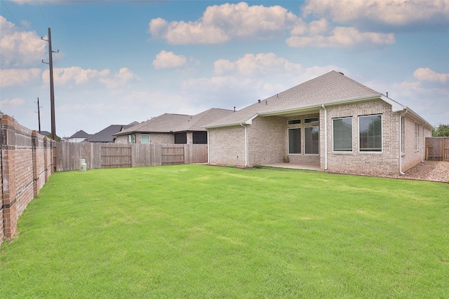 24526 Bluestar Blossom Trl, Katy, TX 77493 - back of house with brick siding, a fenced backyard, and roof with shingles