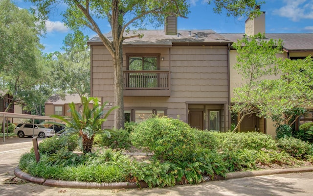 11711 Memorial Dr Unit 635, Houston, TX 77024 - view of side of home featuring a chimney and covered parking