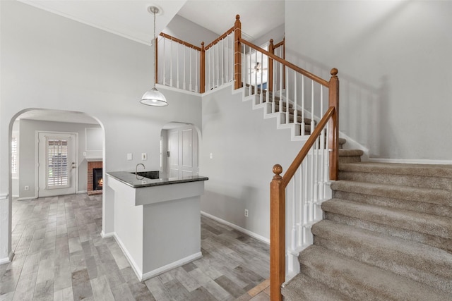 902 Mulberry Ridge Way, Houston, TX 77062 - staircase with wood finished floors, arched walkways, a high ceiling, and a fireplace