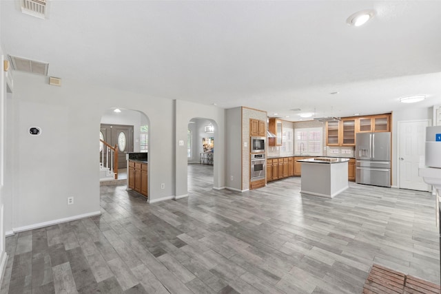 902 Mulberry Ridge Way, Houston, TX 77062 - unfurnished living room with arched walkways, plenty of natural light, light wood-type flooring, and recessed lighting