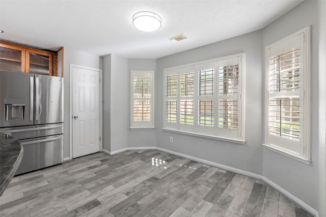 902 Mulberry Ridge Way, Houston, TX 77062 - kitchen with stainless steel fridge, light wood-style flooring, and glass insert cabinets