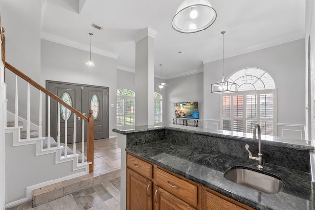 902 Mulberry Ridge Way, Houston, TX 77062 - kitchen with brown cabinets, plenty of natural light, dark stone countertops, ornamental molding, and ceiling fan