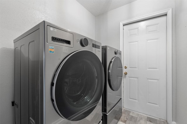 902 Mulberry Ridge Way, Houston, TX 77062 - washroom with washer and clothes dryer, light wood-type flooring, and a textured ceiling