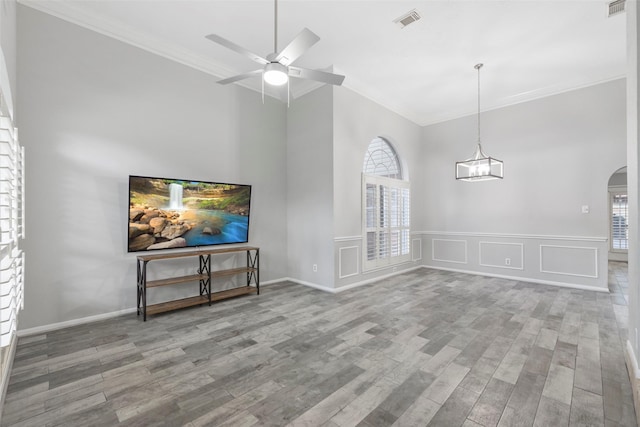 902 Mulberry Ridge Way, Houston, TX 77062 - unfurnished living room with crown molding, arched walkways, wood finished floors, ceiling fan, and a decorative wall
