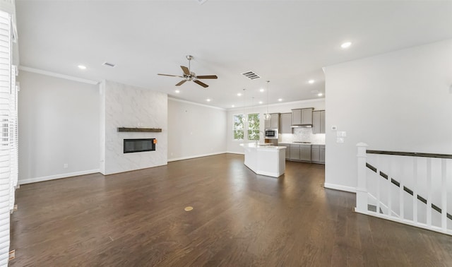 2016 Windsor Meadow Trce, Houston, TX 77051 - unfurnished living room with a ceiling fan, ornamental molding, dark wood-style floors, recessed lighting, and a fireplace