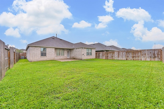 19911 Paros Island Dr, Hockley, TX 77447 - back of house with brick siding, a fenced backyard, a patio, and roof with shingles