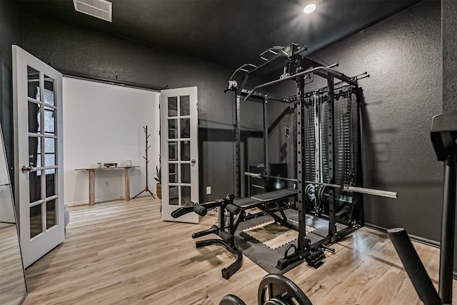 19911 Paros Island Dr, Hockley, TX 77447 - workout room featuring a textured wall, wood finished floors, and french doors