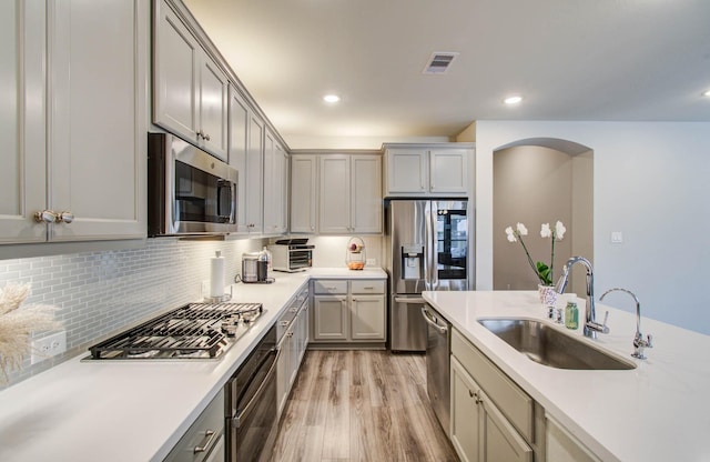 15023 Eves Necklace Ct, Cypress, TX 77433 - kitchen with appliances with stainless steel finishes, gray cabinets, light wood-type flooring, light countertops, and backsplash