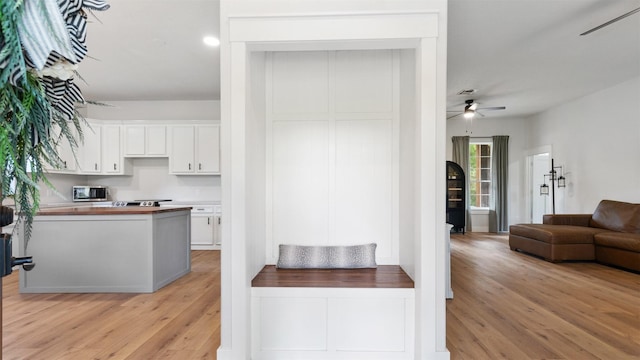 27938 Deer Run St, Montgomery, TX 77356 - kitchen featuring stainless steel microwave, white cabinetry, light wood-type flooring, a ceiling fan, and open floor plan