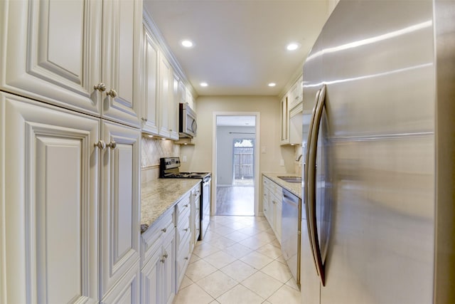 14436 Misty Meadow Ln, Houston, TX 77079 - kitchen with stainless steel appliances, recessed lighting, light tile patterned floors, tasteful backsplash, and white cabinetry
