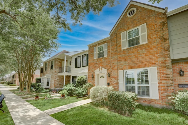 14436 Misty Meadow Ln, Houston, TX 77079 - view of front of home featuring brick siding, a front lawn, and a balcony
