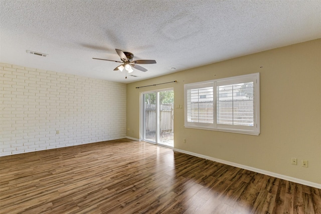 14436 Misty Meadow Ln, Houston, TX 77079 - spare room with wood finished floors, ceiling fan, a textured ceiling, and brick wall