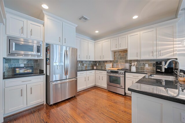 5307 Nett St Unit C, Houston, TX 77007 - kitchen with appliances with stainless steel finishes, white cabinetry, decorative backsplash, and recessed lighting