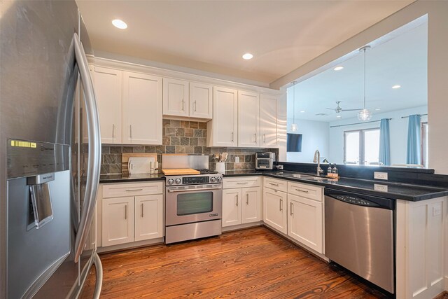 5307 Nett St Unit C, Houston, TX 77007 - kitchen featuring stainless steel appliances, dark countertops, dark wood finished floors, a peninsula, and recessed lighting