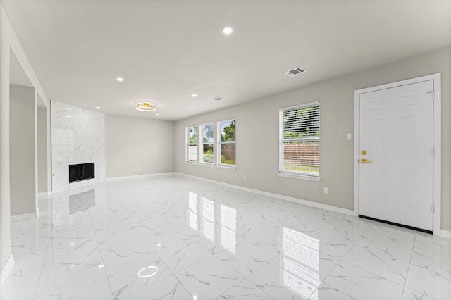 7347 Liberty Ridge Ln, Houston, TX 77049 - unfurnished living room featuring recessed lighting, light marble finish floors, and a premium fireplace