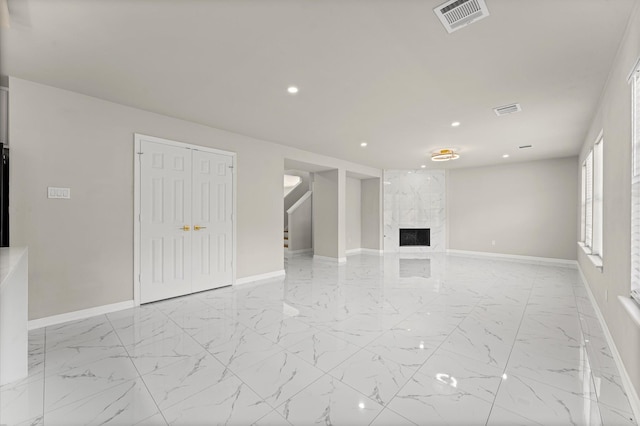 7347 Liberty Ridge Ln, Houston, TX 77049 - unfurnished living room featuring recessed lighting, light marble finish flooring, a premium fireplace, and stairs