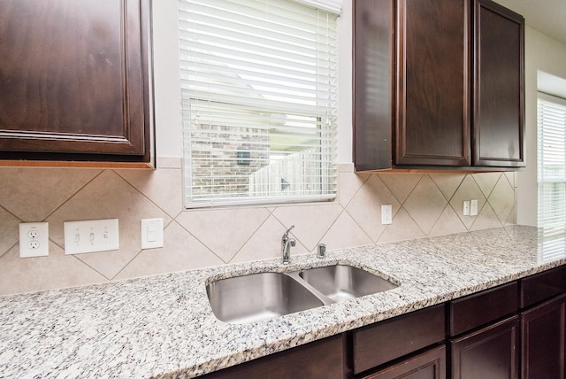 24914 Alberti Sonata Dr, Katy, TX 77493 - kitchen with dark brown cabinets, decorative backsplash, and light stone counters