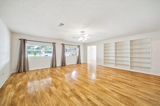 3006 Hartwick Rd, Houston, TX 77093 - empty room with light wood-style floors, ceiling fan, a textured ceiling, and built in features