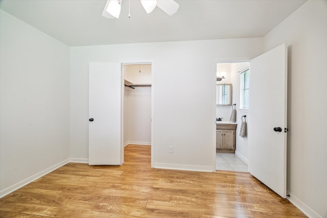 3006 Hartwick Rd, Houston, TX 77093 - unfurnished bedroom featuring a walk in closet, light wood-type flooring, ensuite bathroom, and a ceiling fan