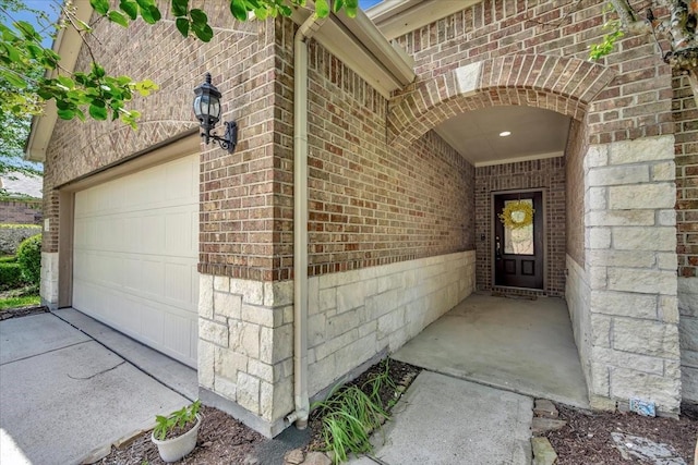 716 Saturnia Ln, League City, TX 77573 - view of exterior entry featuring brick siding, an attached garage, and concrete driveway