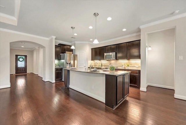 716 Saturnia Ln, League City, TX 77573 - kitchen with stainless steel microwave, arched walkways, dark wood-type flooring, dark brown cabinetry, and recessed lighting