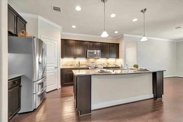 716 Saturnia Ln, League City, TX 77573 - kitchen featuring stainless steel appliances, dark wood finished floors, dark brown cabinets, backsplash, and light stone countertops