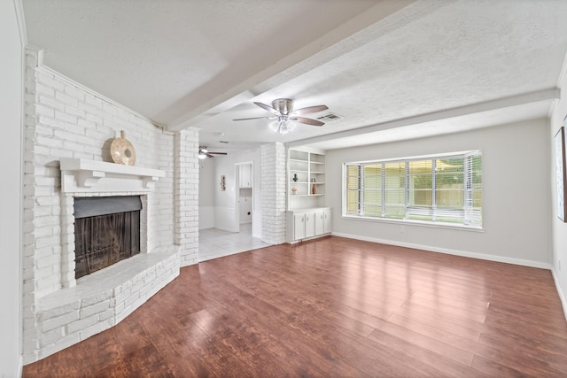11826 Bandlon Dr, Houston, TX 77072 - unfurnished living room with a textured ceiling, a brick fireplace, ceiling fan, wood finished floors, and beam ceiling