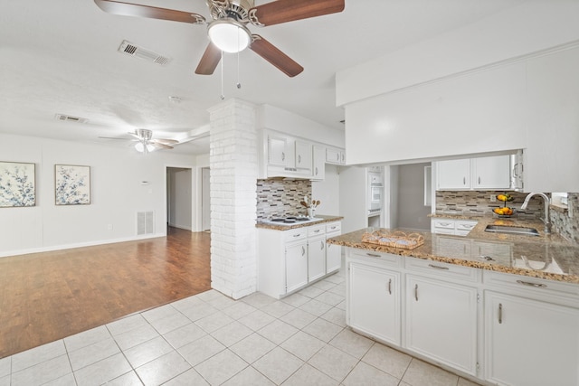 11826 Bandlon Dr, Houston, TX 77072 - kitchen with a ceiling fan, backsplash, light tile patterned floors, light stone countertops, and white cabinets