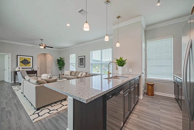 915 Lakeland Cir, Rosharon, TX 77583 - kitchen featuring arched walkways, dishwashing machine, stainless steel fridge, light wood finished floors, and light stone counters