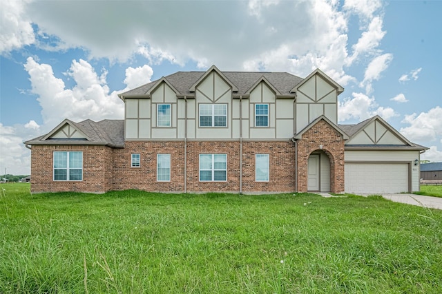 915 Lakeland Cir, Rosharon, TX 77583 - tudor-style house featuring stucco siding, a front lawn, concrete driveway, and an attached garage