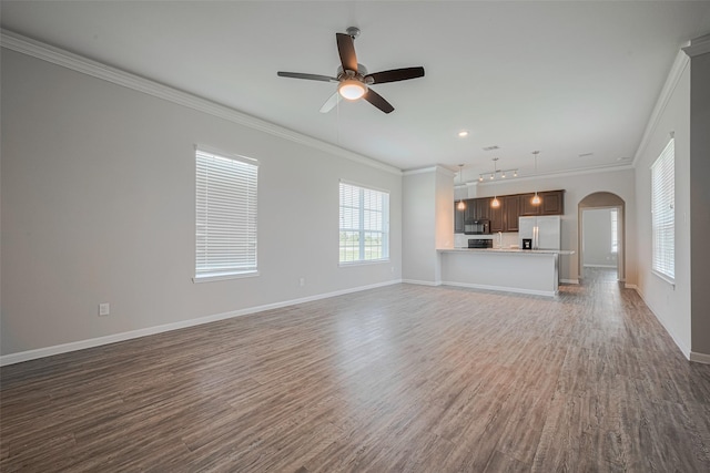 915 Lakeland Cir, Rosharon, TX 77583 - unfurnished living room with arched walkways, a ceiling fan, crown molding, dark wood finished floors, and recessed lighting
