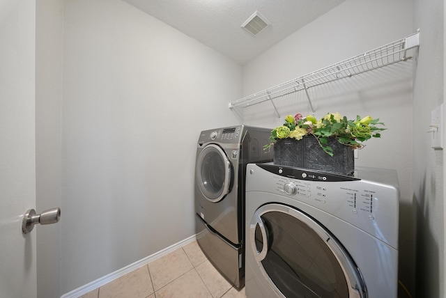 10335 Caribou Cv, Missouri City, TX 77459 - laundry room featuring washing machine and clothes dryer and light tile patterned floors