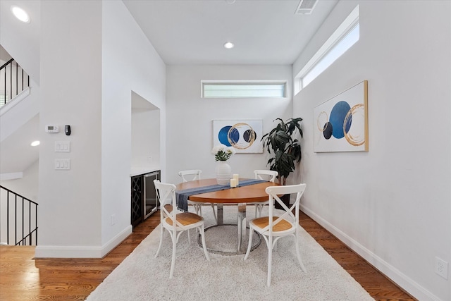 1211 Bonner St, Houston, TX 77007 - dining space featuring stairs, wood finished floors, a towering ceiling, and recessed lighting