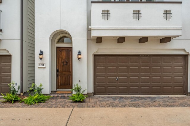 1211 Bonner St, Houston, TX 77007 - view of front of house with decorative driveway, an attached garage, and stucco siding