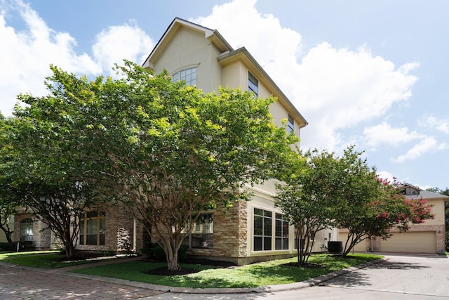 9103 Creekstone Lake Dr, Houston, TX 77054 - view of property hidden behind natural elements featuring stucco siding, driveway, and stone siding