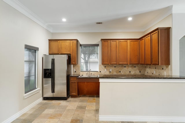 9103 Creekstone Lake Dr, Houston, TX 77054 - kitchen featuring stainless steel refrigerator with ice dispenser, brown cabinets, tasteful backsplash, ornamental molding, and dark stone counters