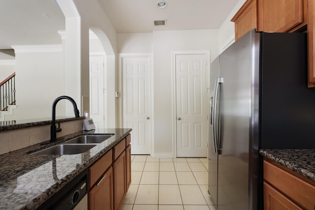 9103 Creekstone Lake Dr, Houston, TX 77054 - kitchen featuring stainless steel refrigerator with ice dispenser, brown cabinetry, dark stone countertops, and arched walkways