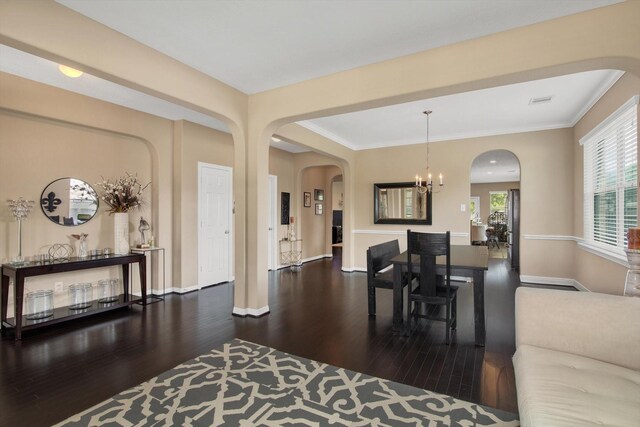 3215 W Trail Dr, Pearland, TX 77584 - dining room with wood finished floors, a chandelier, arched walkways, and ornamental molding