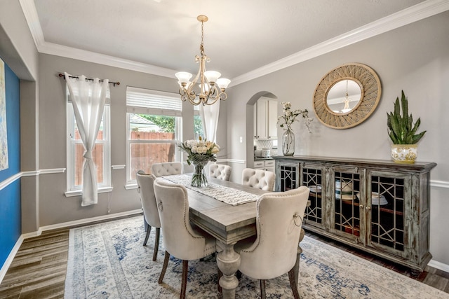 9227 Forest Creek Dr, Tomball, TX 77375 - dining area featuring wood finished floors, arched walkways, a chandelier, and ornamental molding
