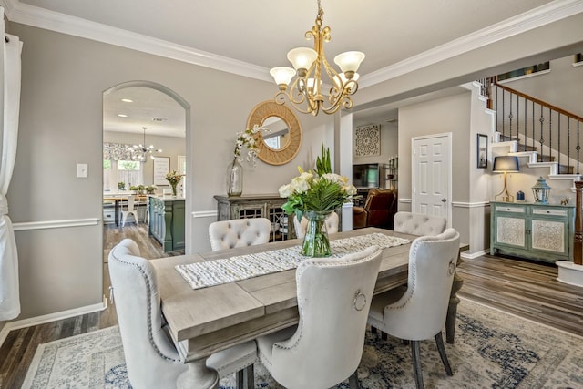 9227 Forest Creek Dr, Tomball, TX 77375 - dining room with a chandelier, dark wood-type flooring, ornamental molding, stairs, and arched walkways