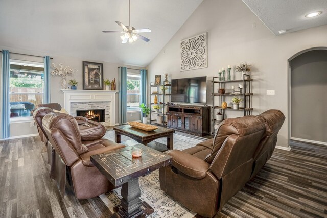9227 Forest Creek Dr, Tomball, TX 77375 - living area with wood finished floors, a ceiling fan, a warm lit fireplace, arched walkways, and high vaulted ceiling