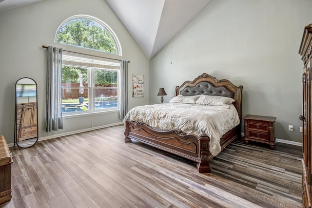 9227 Forest Creek Dr, Tomball, TX 77375 - bedroom with multiple windows, wood finished floors, and high vaulted ceiling