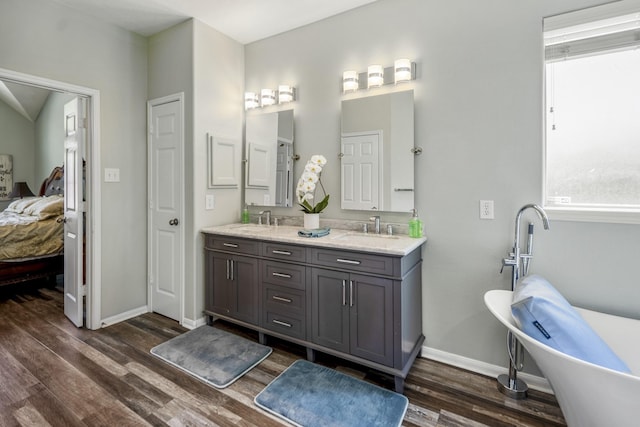 9227 Forest Creek Dr, Tomball, TX 77375 - ensuite bathroom with double vanity, wood finished floors, and a freestanding bath