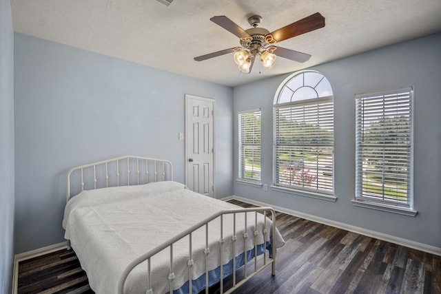9227 Forest Creek Dr, Tomball, TX 77375 - bedroom with dark wood-type flooring, a ceiling fan, and a textured ceiling