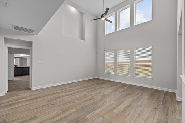 3122 Banyan Dr, Texas City, TX 77510 - unfurnished living room with a towering ceiling, light wood-style flooring, and a ceiling fan